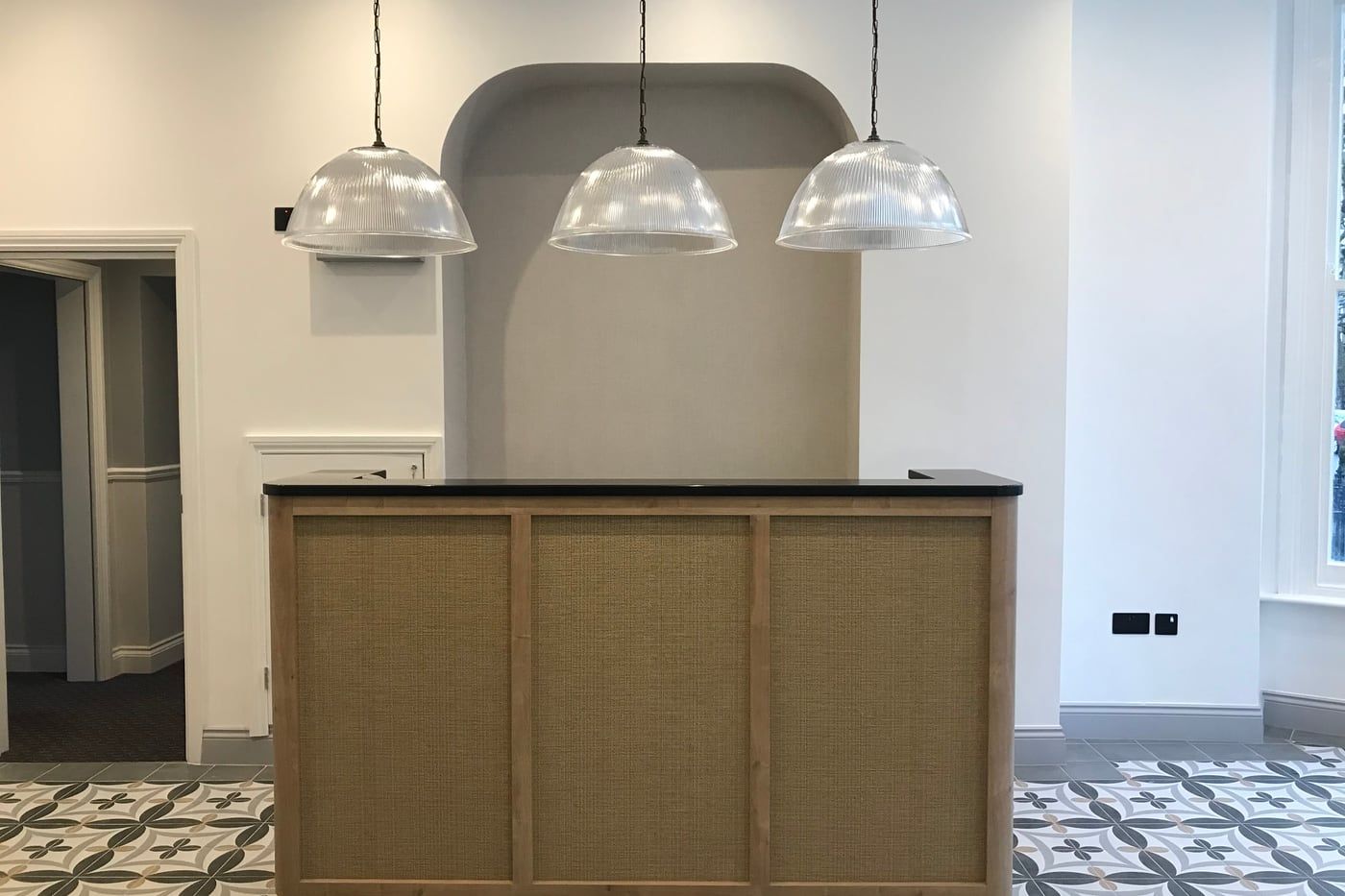The reception desk being built: carcass in place, walls unpainted and the encaustic floor tiles already laid